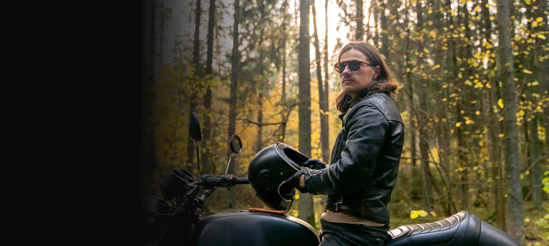 Biker wearing a premium black leather motorcycle jacket on his motorcycle